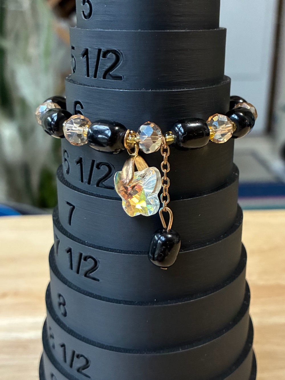 Black and Gold Beaded Stretch Bracelet with Iridescent Flower Charm - Picture 1 of 9